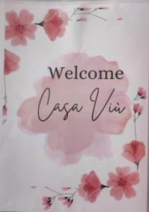 a sign that says welcome caira viii with pink flowers at Casa di Viu' in Viù