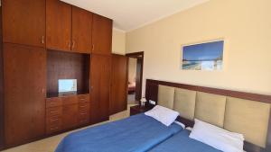a bedroom with a blue bed and wooden cabinets at VILLA PAGONI Residence Selini Villas N 1 Kolymbari Chania in Kolymvari