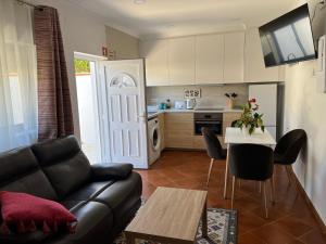 a living room with a couch and a table and a kitchen at Farm stay in Maceira, Leiria 