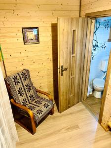 a room with a toilet and a chair and a door at Wiejskie Zacisze in Wiele
