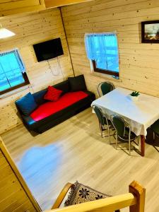 ein Wohnzimmer mit einem roten Sofa und einem Tisch in der Unterkunft Wiejskie Zacisze in Wiele