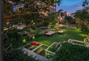 a garden with a table and benches in the grass at Edge Luxury Ocean view Pattaya in Pattaya Central