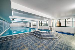 a swimming pool with a tub and stairs in a house at Terrific 2 Bed 2 Bath Apt with gym & roof terrace -12 mins from Central London in London