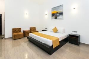 a bedroom with a bed and two chairs at Polhena Grand Resort & Banquet in Matara