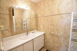 a bathroom with a sink and a mirror at Villa berges landaises location vacances spacieuse Villa avec piscine chauffée capbreton in Capbreton +2 photos