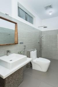 a bathroom with a sink and a toilet and a shower at Polhena Grand Resort & Banquet in Matara +110 photos