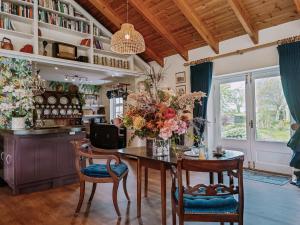 uma sala de jantar com uma mesa com um vaso de flores em Balsoon Lodge em Navan