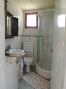 y baño con aseo, lavabo y ducha. en House Zrno, en Račišće