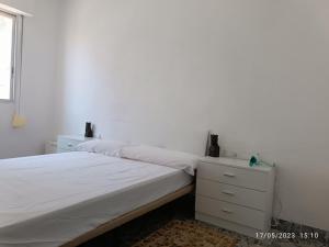 a white bedroom with a bed and a dresser at Playa Sant Antonio muy cercana in Cullera