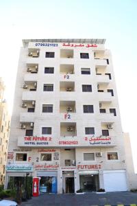 un edificio alto y blanco con balcones. en Future 2 Hotel Apartments en Áqaba