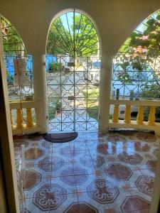 a room with a floor with a table and windows at Fay Guest House in Negril
