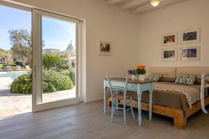 Schlafzimmer mit einem Bett, einem Tisch und einem Fenster in der Unterkunft Ostuni Art Resort in Ostuni