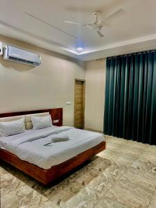- une chambre avec un grand lit et un rideau bleu dans l'établissement HOTEL SKYZ, à Sirsa