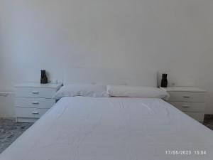 a white bed with two pillows in a bedroom at Playa Sant Antonio muy cercana in Cullera
