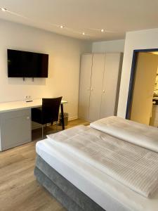 1 Schlafzimmer mit 2 Betten, einem Schreibtisch und einem TV in der Unterkunft Hotel Wittlicher Hof in Wittlich