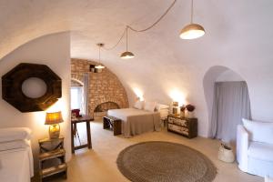 a bedroom with a bed and a couch in a room at Masseria Soluco in Monopoli