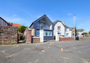 a house with a black roof in a street at Old Coastguard Station in Dunbar