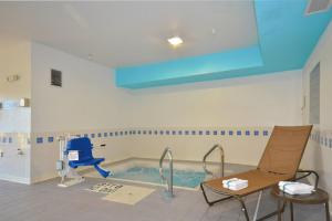 a swimming pool in a room with a blue chair at Freedom Inn in Springfield