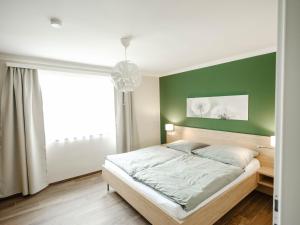 a bedroom with a green accent wall and a bed at Ferienhaus Sporr in Herrnbaumgarten