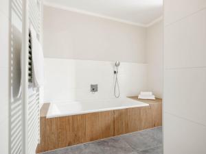 a white bathroom with a bath tub in it at Ferienhaus Sporr in Herrnbaumgarten
