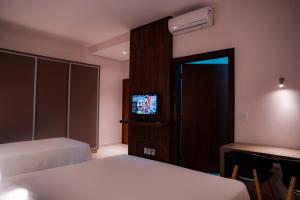 a hotel room with two beds and a television at Hotel Santos Dumont in Goiânia