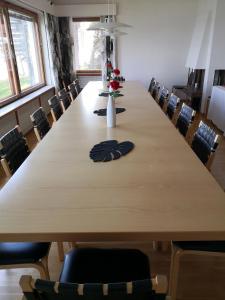 een grote houten tafel in een kamer met stoelen bij Club House Hotelli Kaipolan Ranta in Jämsä