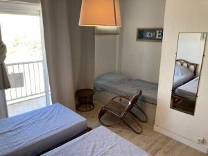Cette petite chambre comprend 2 lits et un miroir. dans l'établissement Appartement Le Lavandou, 2 pièces, 4 personnes - FR-1-308-82, au Lavandou