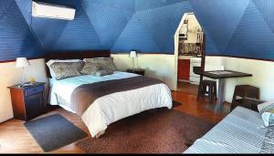 a bedroom with a blue ceiling with a bed at Lircaydomohostal - Domo 40m2 para 4 personas in Talca