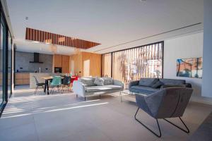 ein Wohnzimmer mit Sofas und einem Tisch sowie eine Küche in der Unterkunft Inmovecos Villa Gawy 2 de Lujo con piscina privada in La Manga del Mar Menor