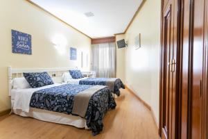 Łóżko lub łóżka w pokoju w obiekcie Hotel América Ferrol