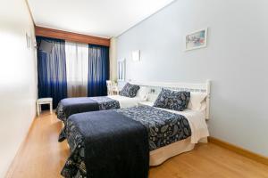 Łóżko lub łóżka w pokoju w obiekcie Hotel América Ferrol