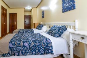dwa łóżka z niebieską i białą pościelą w pokoju w obiekcie Hotel América Ferrol w mieście Ferrol