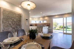 a dining room with a table with wine glasses at Mali Apartments Garden Suite in Tirolo