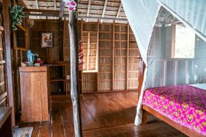 ein Schlafzimmer mit einem Bett in einem Zimmer mit Holzböden in der Unterkunft Methos Homestay - Raja Ampat in Yennanas Besir