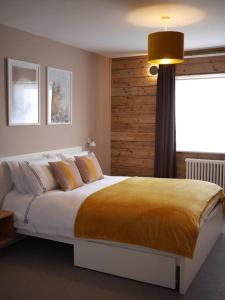 um quarto com uma cama grande e um cobertor amarelo em 55 High Street em Hastings