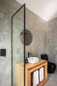 a bathroom with a sink and a mirror at LalaGalu - Beachfront EcoCabins in Diani Beach