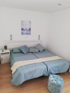 łóżko z niebieską pościelą i niebieską otomaną w pokoju w obiekcie Canaima 306 w mieście Puerto Rico de Gran Canaria +37 zdjęć