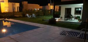 un patio trasero con piscina por la noche en LA ESQUINA DE LA FLOR en Campo Quijano