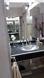baño con lavabo y espejo grande en LA ESQUINA DE LA FLOR en Campo Quijano