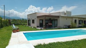 Villa con piscina frente a una casa en LA ESQUINA DE LA FLOR en Campo Quijano