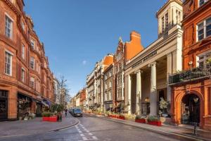 eine Stadtstraße mit Gebäuden und einem Auto auf der Straße in der Unterkunft Stunning Mayfair 3 bed flat with terrace and fireplace in London