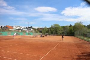 a group of people playing tennis on a tennis court at CenterCourt Hotel in Graz