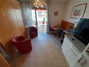 uma sala de estar com televisão e uma mesa com cadeiras em Appartement Fréjus, 1 pièce, 2 personnes - FR-1-226A-356 em Fréjus