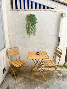 a table and two chairs sitting next to a wall at ô petit charme in Nîmes