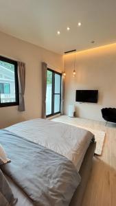 a bedroom with a large bed and a flat screen tv at Lucid Dream清醒夢民宿 in Yilan City