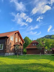 una casa in un giardino con prato verde di Зачаровані Карпати, Воловець a Volovets