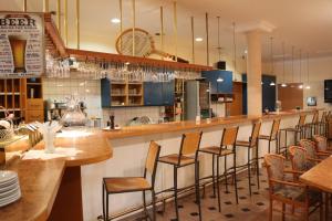 un restaurante con bar con taburetes de madera en CenterCourt Hotel, en Graz