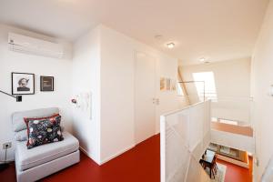 uma sala de estar com piso vermelho e paredes brancas em Julius 25 Modern Comfort - 5 Mins to Vienna's City Center em Viena