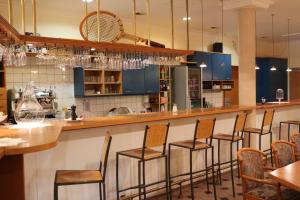 a bar in a restaurant with chairs and a counter at CenterCourt Hotel in Graz