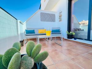 patio z kanapą, stołem i kaktusem w obiekcie Rincón de Luz y Mar w mieście Retamar